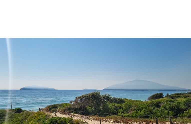 Smoke drifts over the coast, leaving a thick blanket above the water at Bennetts Beach, Hawks Nest. Photo: Thomas O’Keefe.