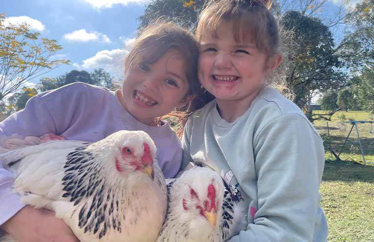 The kids also thrive when they’re out in the paddock with the chooks. Photo: Supplied.